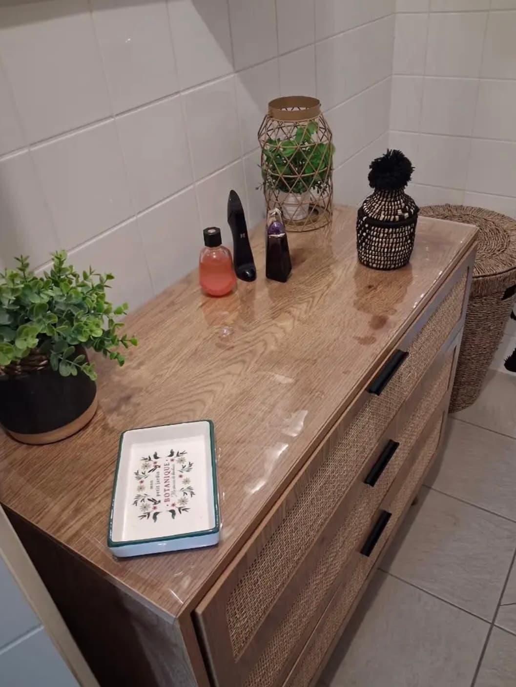 Cómoda madera y ratán: en el suelo la estera, el próximo jabón, la linterna y una planta
