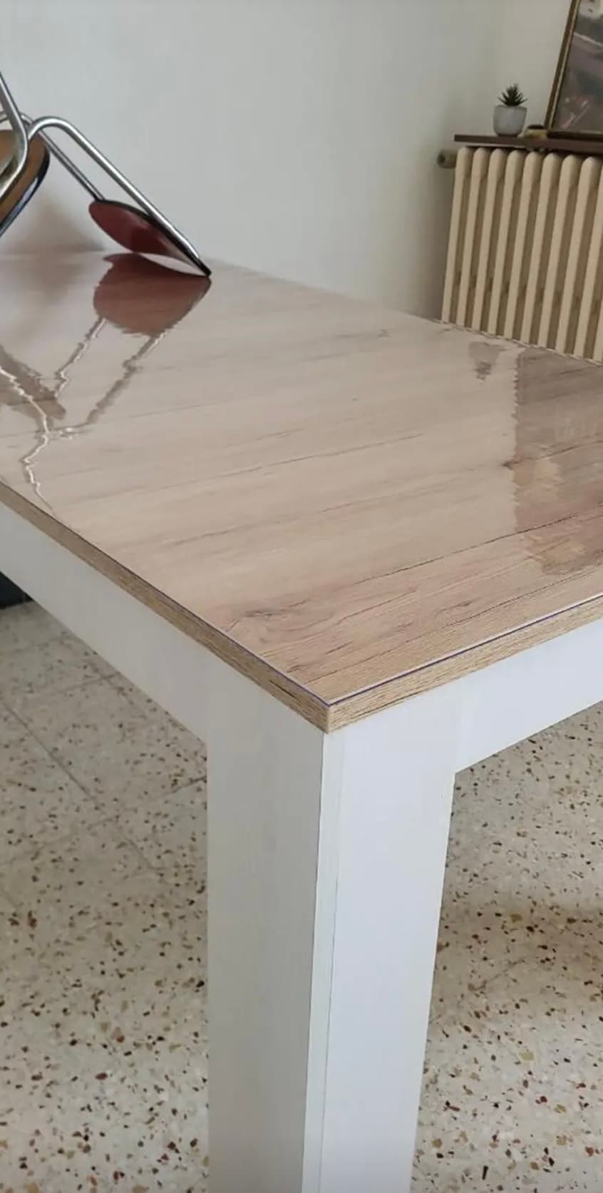 Piso claro sobre las piernas blancas con el reflejo de la estera; en el fondo un radiador en hierro fundido