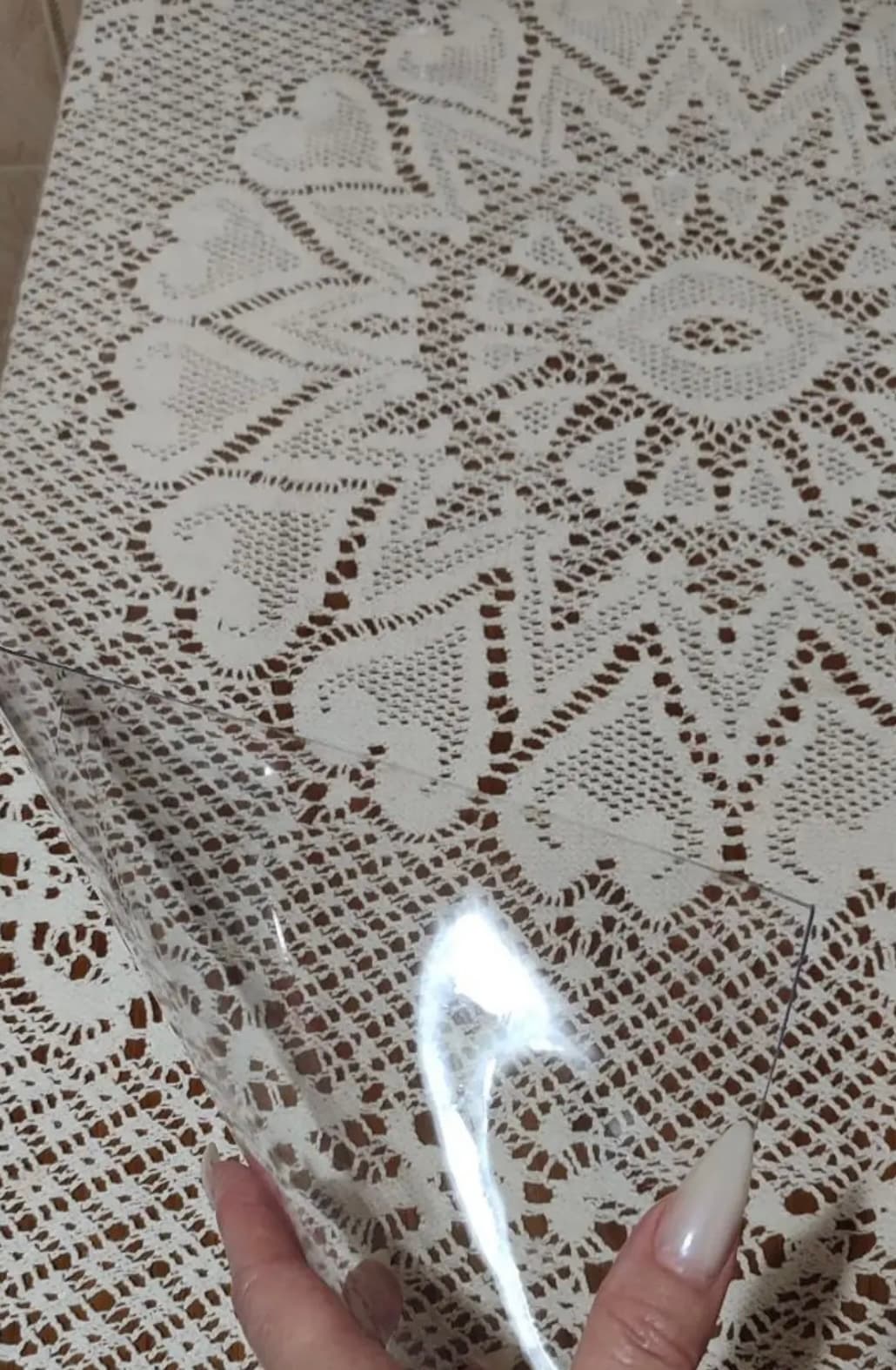 alfombra transparente sobre un mantel de ganchillo: el bordado permanece perfectamente visible