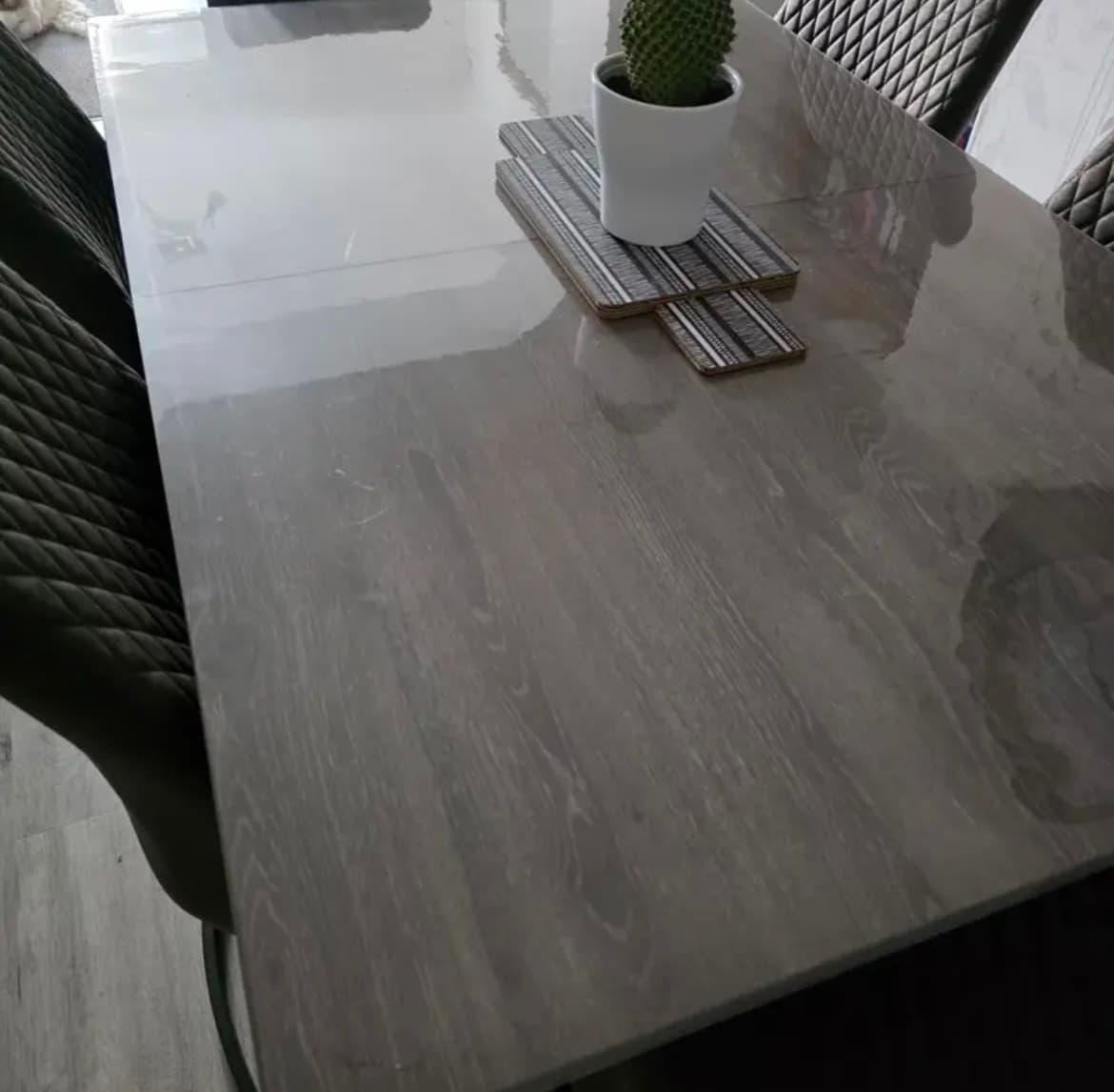 Mesa de madera gris con cactus en techos de madera, alrededor de sillas acolchadas