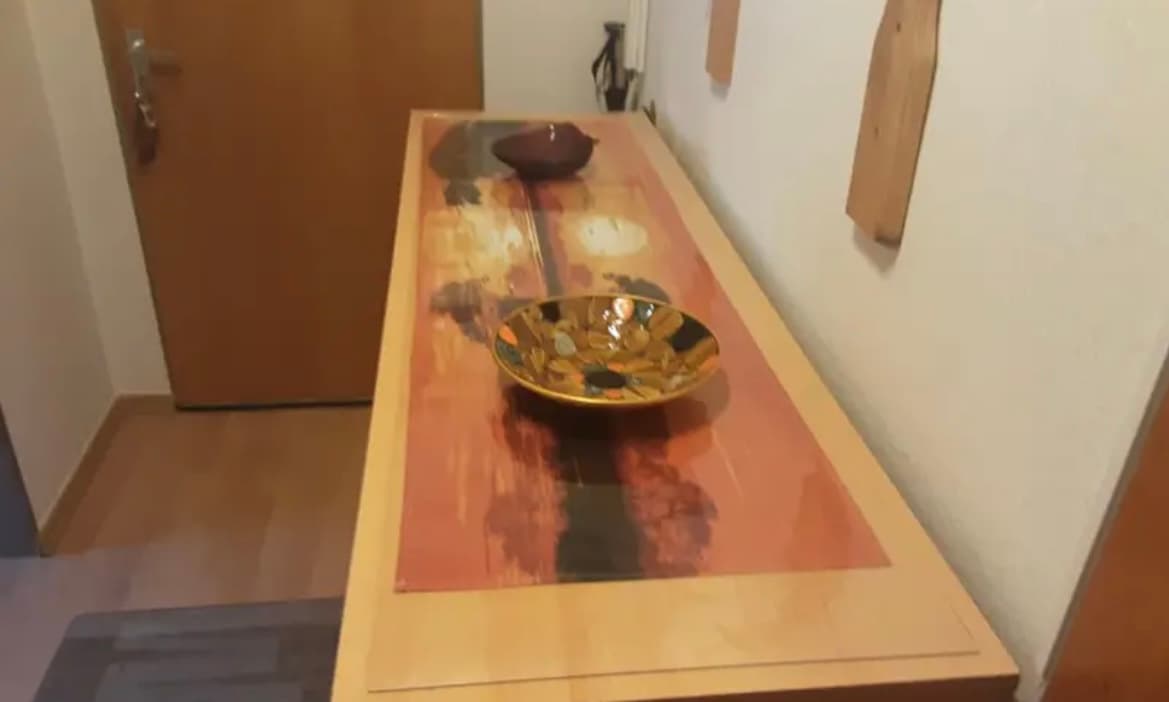 Mesa de entrada: debajo de la alfombra el patrón rojo de la parte superior, sobre una taza de bronce