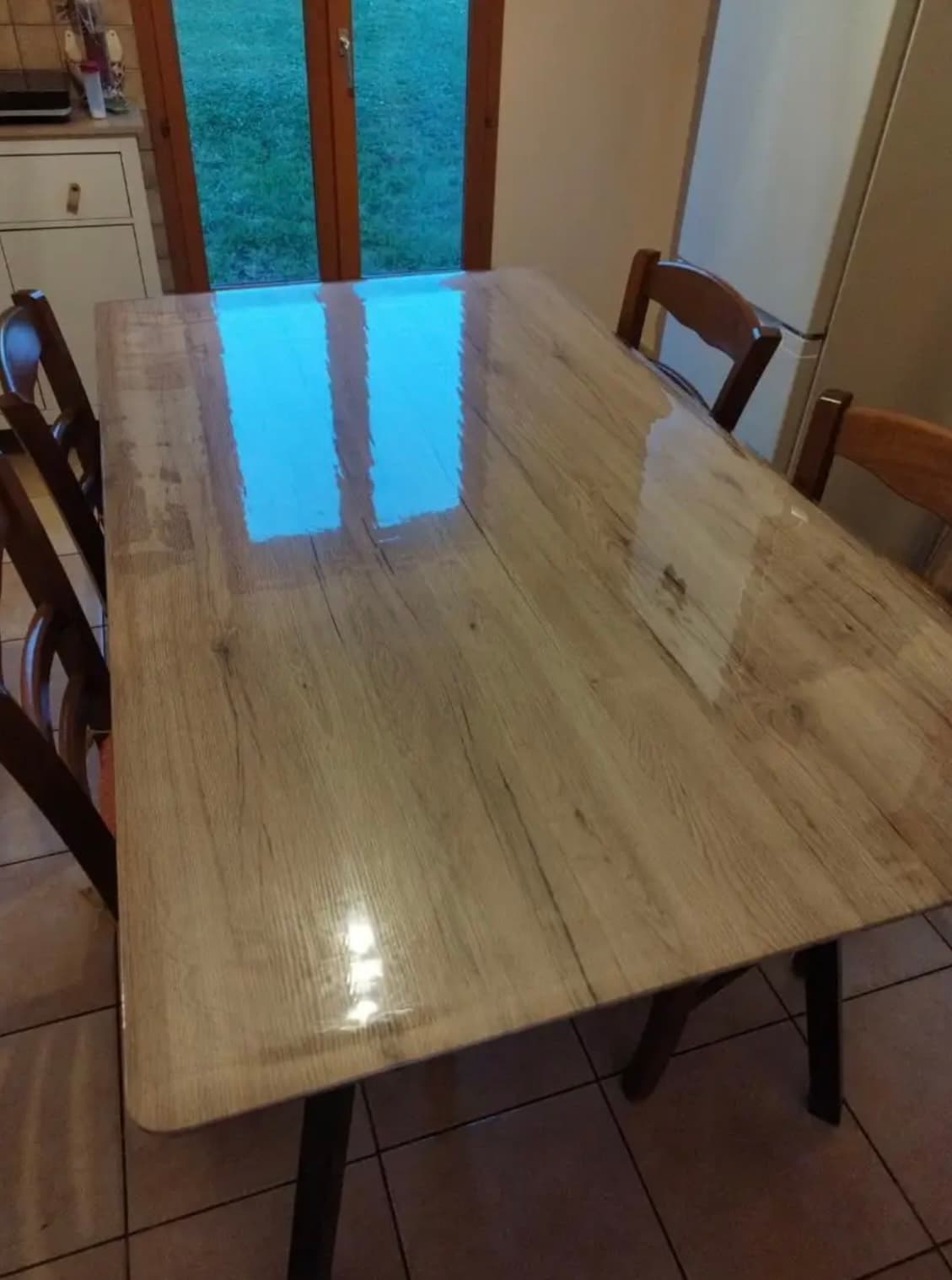 Mesa de cocina de roble claro: en la estera se refleja la ventana en el jardín