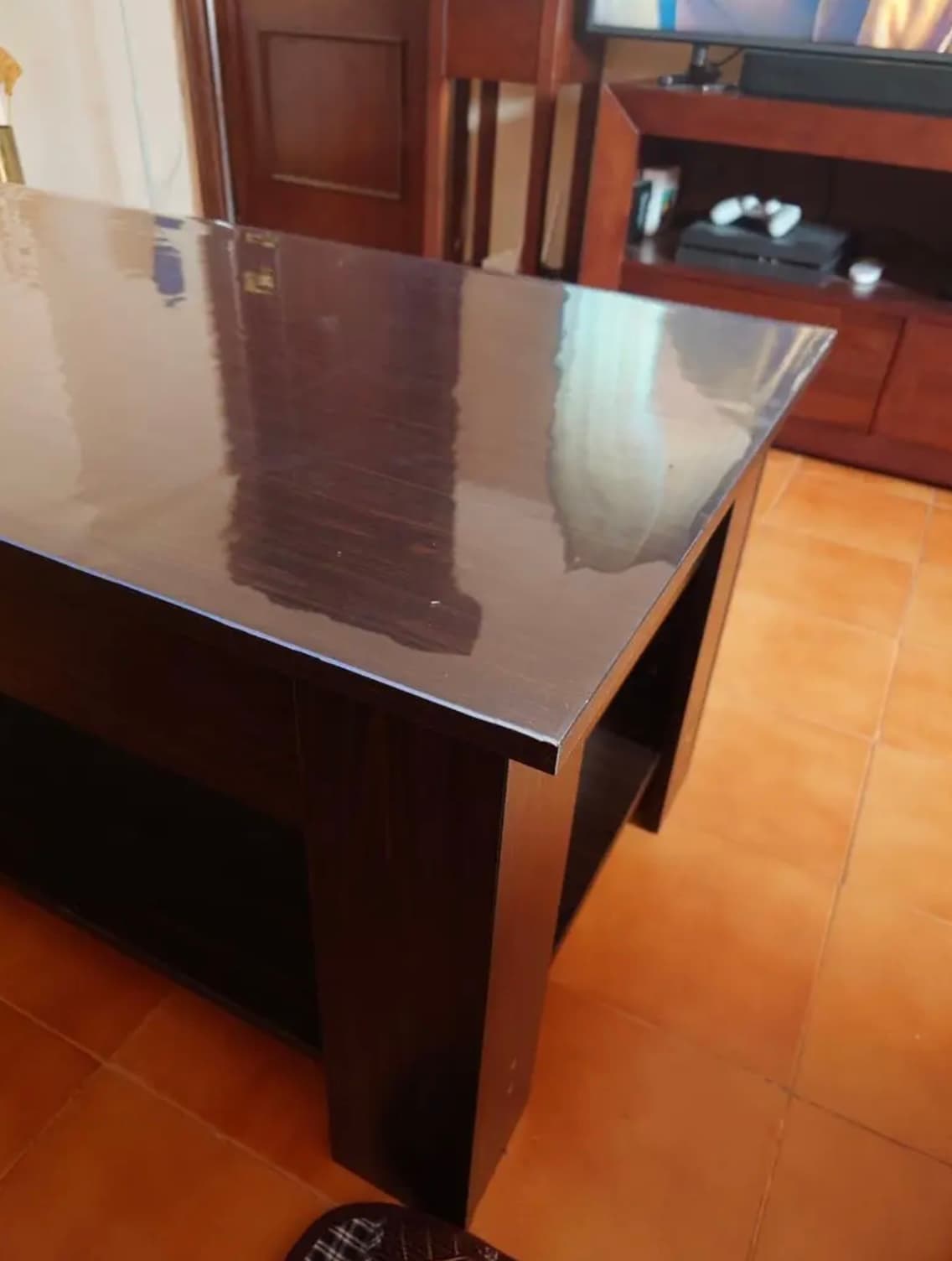 Consola oscura en wenge en salón, piso bajo alfombra transparente, suelo terracotta