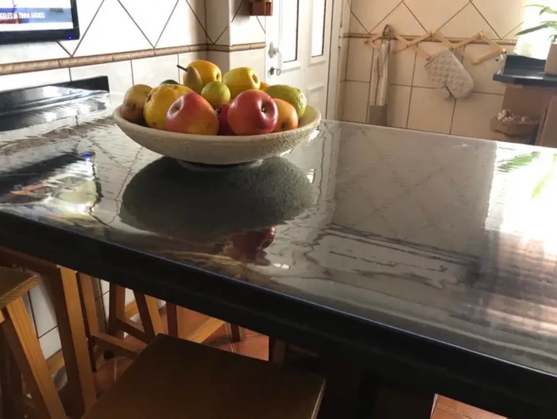 Península de cocina con efecto mármol: el tazón de manzanas y peras descansa en la estera